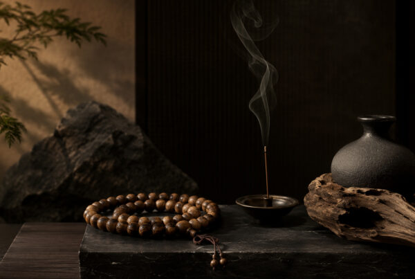 Stacked natural stone jewelry, agarwood bracelet and tea set arranged on linen by a premium spiritual lifestyle brand