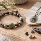 Artisan stone jewelry with a handmade bracelet and pendant on a workbench